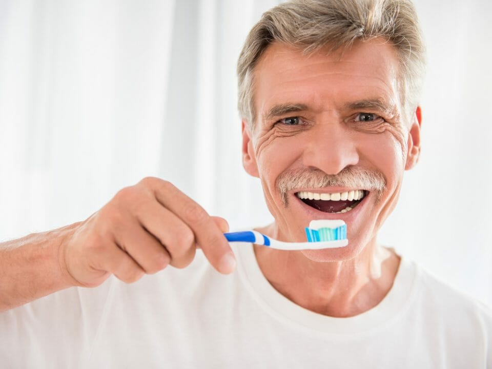 mature man brushing his teeth